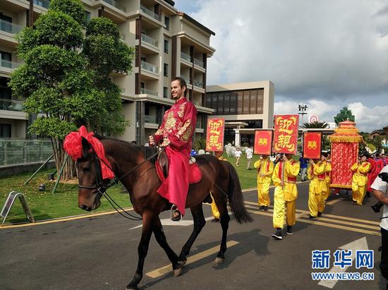 新郎蒂莫身骑骏马带领花轿前往主婚礼场地。（新华网发）