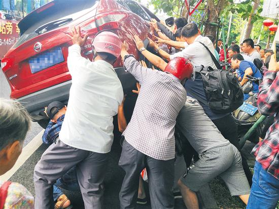 多位市民合力抬车救人。图片由热心市民提供