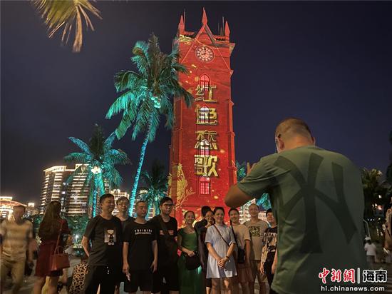  市民游客在《钟楼·红色恋歌》光影秀中合影。符宇群摄