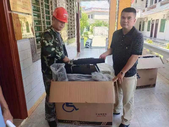 地太村驻村第一书记、乡村振兴工作队队长刘民为群众发放残疾人辅助器具
