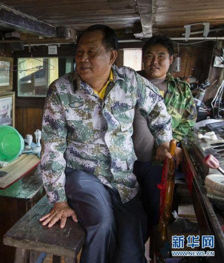 11月14日，在海南省琼海市潭门镇，王书茂(左)在渔船上。 新华社发(宋国强 摄)