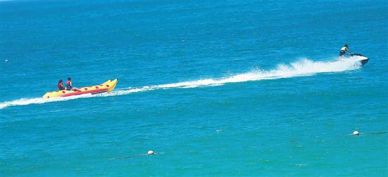 三亚大东海，游客乘坐香蕉船驰骋海浪间。本报记者 李英挺 摄