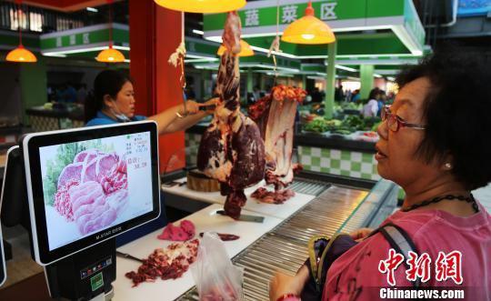 1月16日，三亚市民在乐天城农贸市场买菜。菜一上秤，净重、单价、金额等信息在屏幕上就一目了然。　尹海明 摄