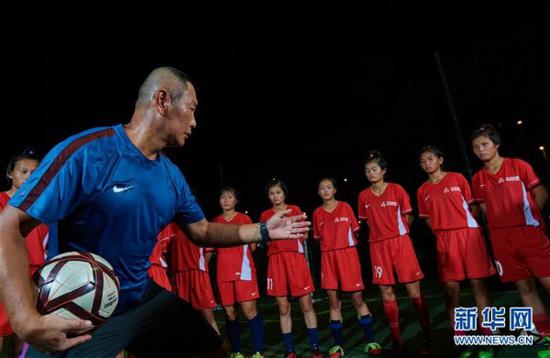 　　8月7日，主教练肖山(前)在海口市世纪公园足球场给队员们讲解战术。新华社记者 赵颖全 摄