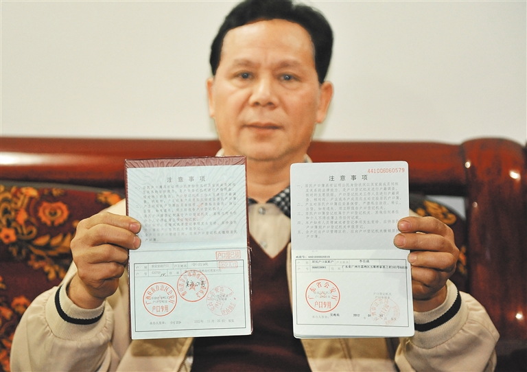 53岁的李会成通过积分入户成为了一名“新广州人”,他的广西户口本(左)换成了广东户口本(2020年1月18日摄)。 新华社记者 卢汉欣 摄
