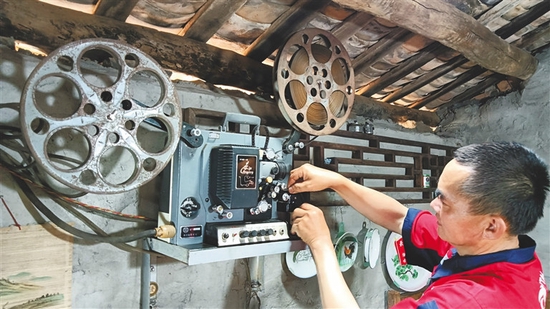 林书国在操作老式胶带电影放映机。记者陈耿摄