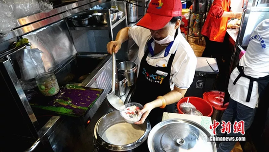 何冠美在为客人制作椰奶清补凉。符宇群摄
