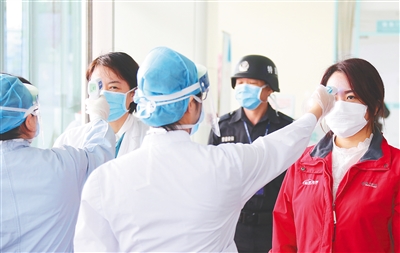 在海南省人民医院，护士为进入门诊楼的群众测量体温。 海南日报记者 李天平 摄