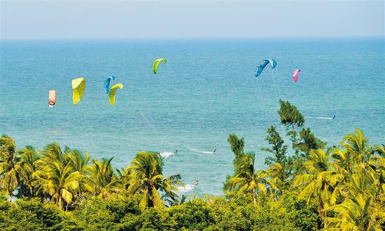 风筝冲浪爱好者在海南的碧海椰风中劈波斩浪。海南日报记者 王凯 摄