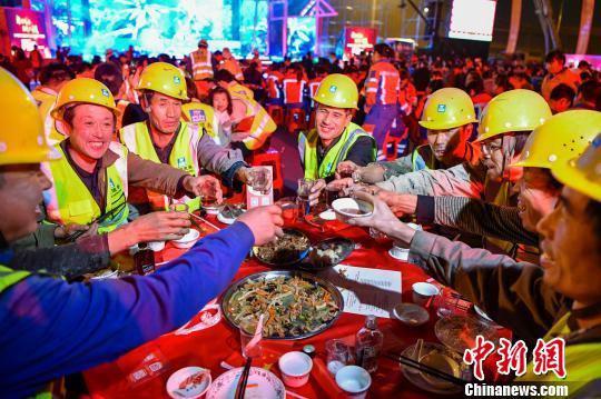 来自中国建筑第八工程局有限公司的工人举杯。　骆云飞　摄