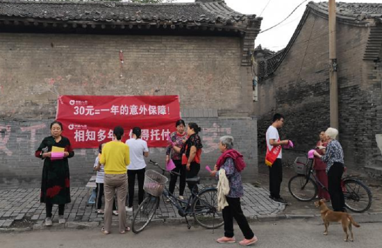 工作人员协助客户通过自助柜员机办理业务