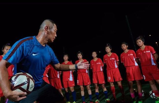 晚上10点半，肖山教练在海口市世纪公园足球场给队员们讲解战术。新华社记者 赵颖全