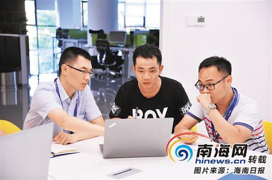 6月11日下午,海南生态软件园集团公司,曾任职于海尔集团的上海大学研究生王绪传(左一),曾任职于华为、IBM等企业的清华大学研究生孙江宇(中)和同事讨论工作。通讯员杨裕宁摄