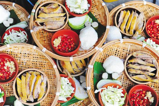 富有特色的琼海“公道”餐包括鸭肉、青菜、鸭汤和饭团，以椰壳汤碗、竹编餐盘盛放，每人一份，用手抓食。