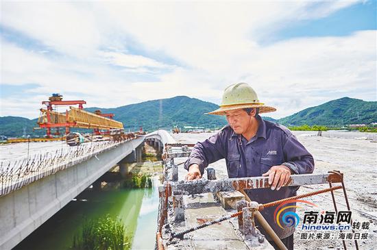 9月11日,亚龙湾第二通道(一期)工程,工人们在烈日下作业。图为工人正在搭建大茅河桥两侧护栏。见习记者 封烁 摄