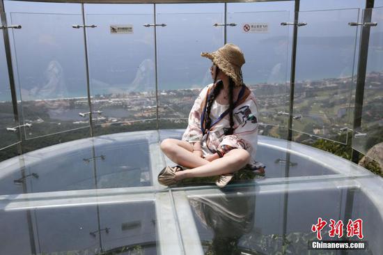 三亚首条海景玻璃栈道近日开门迎客，游客在栈道上牌照留念。王晓斌 摄