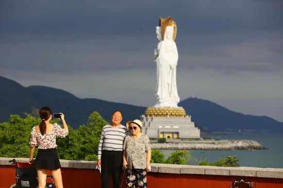 12月17日，老人在家人陪同下到三亚南山文化旅游区游览、留影。