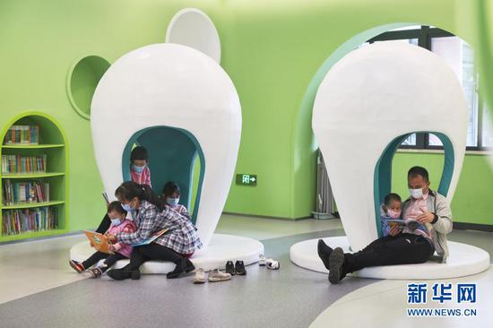 1月24日，家长陪伴孩子在海口市龙华区文化馆内读书。新华社记者 张丽芸 摄
