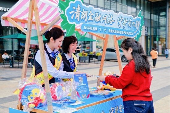  图为建行工作人员向群众发放宣传折页，讲解金融安全知识。