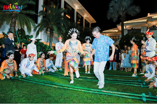 琼港澳台旅游业界中秋赏月联欢活动现场，嘉宾体验黎族竹竿舞。