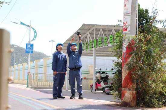 海南电网公司三亚供电局西部配电管理中心工作人员在三亚市天涯小镇检查电车充电站设备运行情况。（卢瑾 摄）
