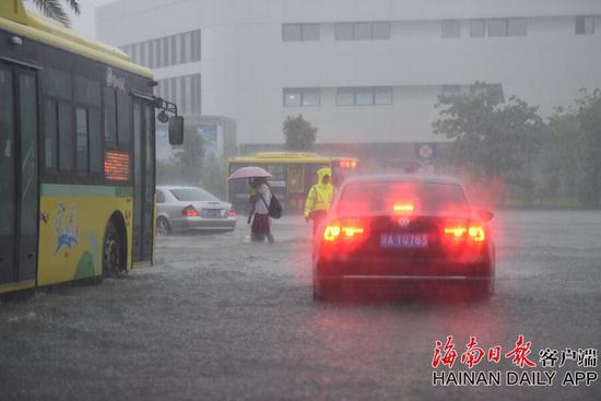 2018年8月10日，暴雨造成海口东的动车站外积水严重，交警在淹没的斑马线旁疏导交通，让刚下车的旅客及时过马路。海南日报记者袁琛 摄