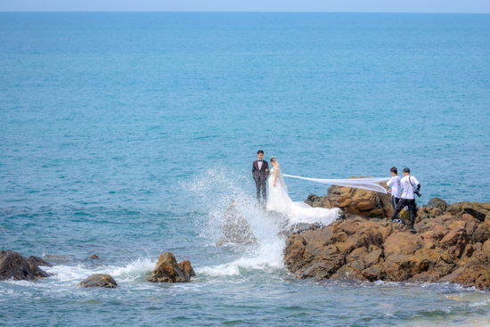 情侣在天涯海角海边拍摄婚纱照