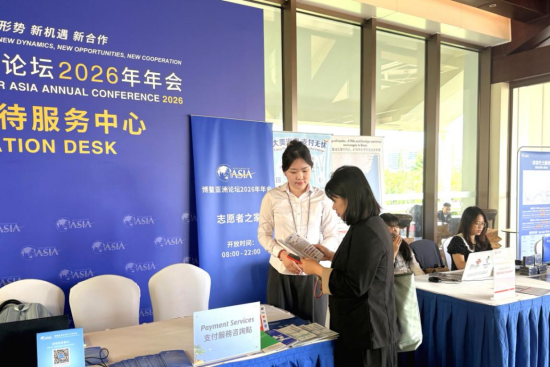  建行工作人员在博鳌亚洲论坛2026年年会会场设立的支付服务咨询点为客户提供服务。