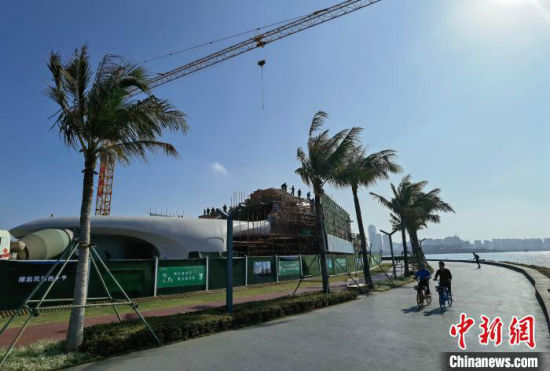 2月1日，海口市民骑行经过正在施工的“海口云洞图书馆”。　尹海明 摄