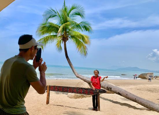 蔡海兴在天涯海角沙滩椰树下为母亲拍照