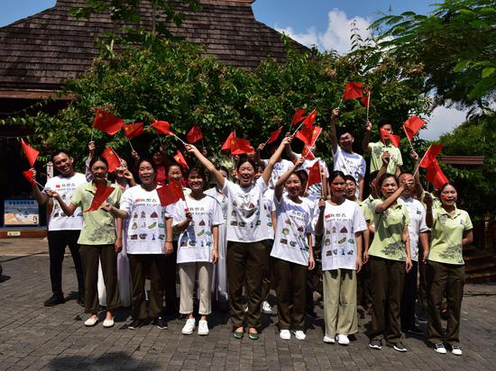 三亚亚龙湾热带天堂森林旅游区天街部分员工，满怀喜悦的心情，手舞着小国旗，庆祝新中国成立70周年！（黄庆优摄）