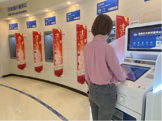 （图：群众在建行省行营业部24小时自助区便民服务站自助机上办理业务）