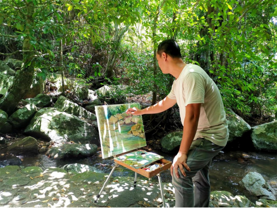 采风团成员在热带雨林中用画笔创作记录所行美景
