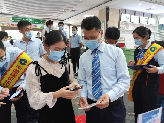 图为建行工作人员指导市民体验数字人民币“一元挂号”活动。