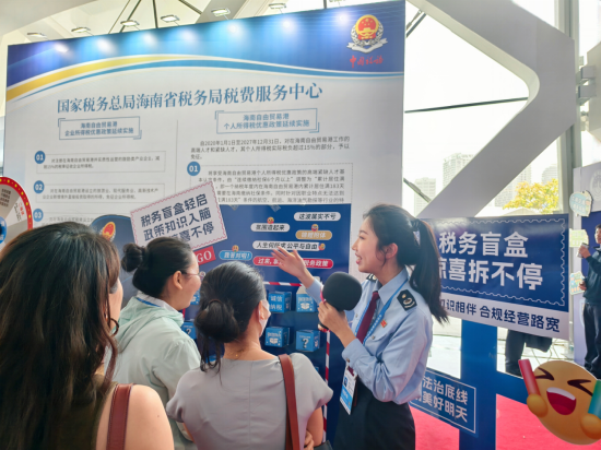 （图为文昌市税务局工作人员为现场观众讲解“税务盲盒惊喜拆不停”活动流程。黄橙诚 摄）