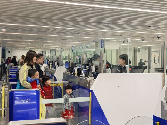 美兰边检站执勤民警为入境旅客办理通关手续，张婉莹摄影