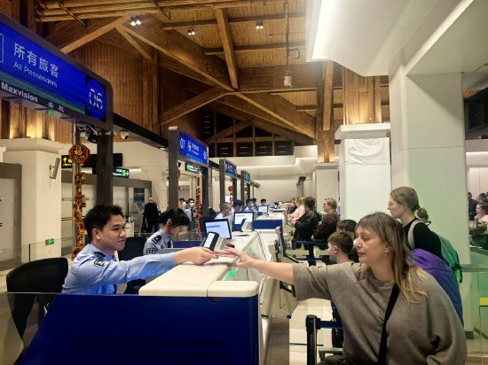 凤凰边检站执勤民警为入境旅客办理通关手续，章晨摄影。