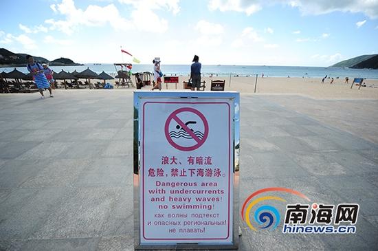 在大东海禁止下海游泳人告示牌后，依照有人在海面上游泳。南海网记者 沙晓峰 摄