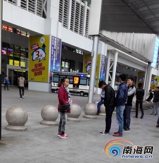 距离警车不远处，站着一群拉客仔，旅客进入海口火车东站，首先要过拉客仔的关。