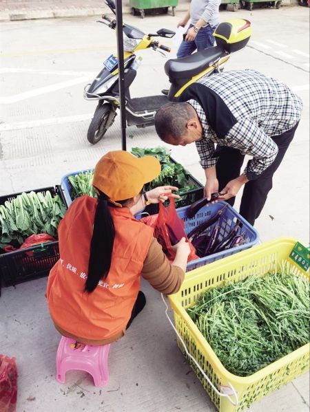 市民在平价菜临时直销点买菜。