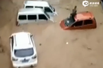 实拍广西暴雨洪流冲走汽车 男子趴车顶求救