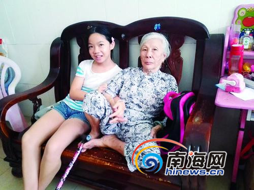 小蕾与奶奶坐在一起，用手挽着奶奶紧张的看着到访的客人。