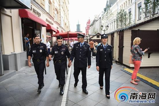 8月10日，在俄罗斯首都莫斯科的尼科利斯基街，三亚旅游警察和执勤的莫斯科旅游警察交流学习。新华社记者戴天放摄