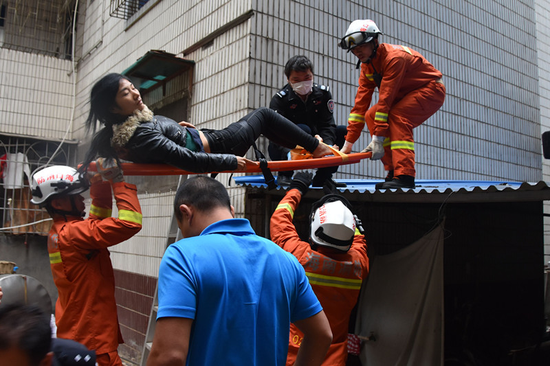 消防员将跳楼女子用担架抬下铁皮棚。图片由琼山消防提供
