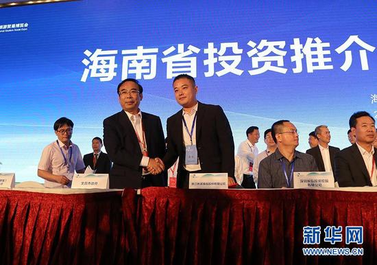 文昌市常务副市长郑有雷（左）与陈毅鸿签约。新华网 周淑仪摄