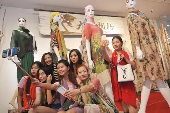 ▲美女主播们在旅游文化商品展区现场促销丝绸时装