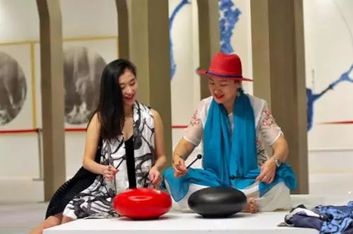 两位女性艺术工作者在交流“钢舌鼓”的演奏技法