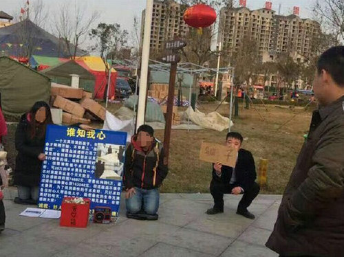 两人在景点跪地乞讨 城管举牌警示骗局