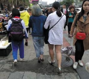 ▲海口街头行人穿衣冬夏齐上阵