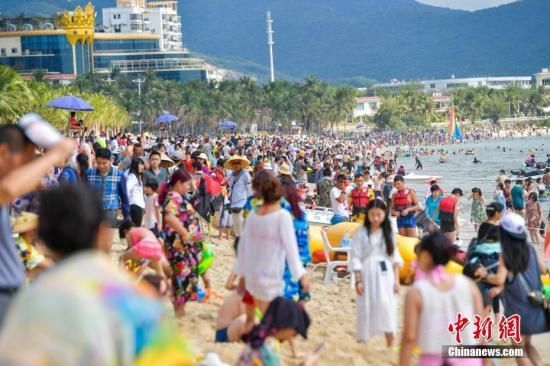 资料图 三亚大东海沙滩上，数万游客畅享椰风海韵阳光沙滩。 中新社记者 骆云飞 摄